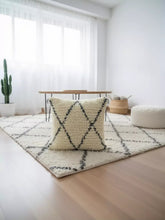 Titrit Berber pillow styled on cream rug in bright modern living room