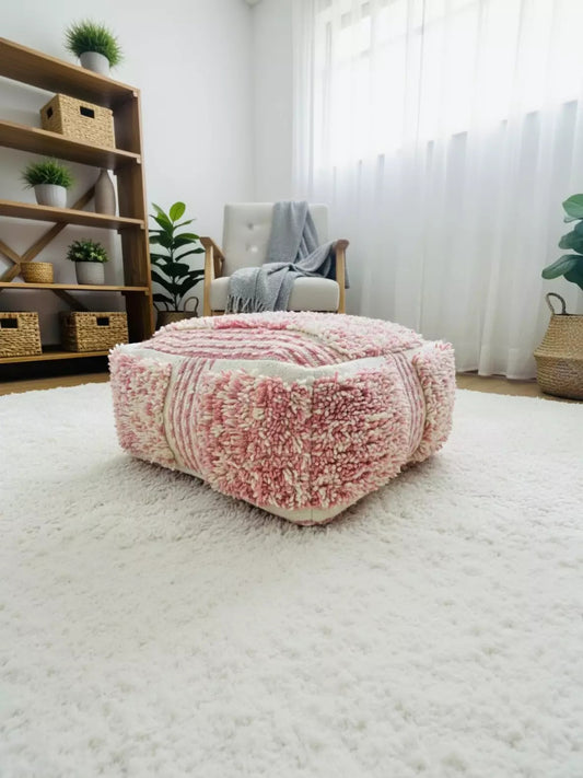 Close-up of a Moroccan pink and white wool pouf with shaggy Berber texture.