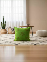 Green Moroccan cactus silk pillow styled in a bohemian living room