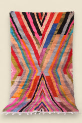 Moroccan Boucherouite rug featuring vivid rainbow-like zigzag patterns and soft wool texture