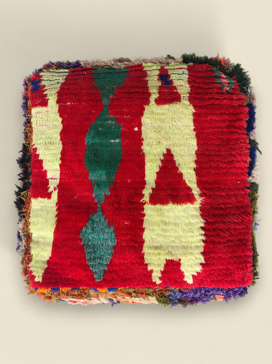 Top view of the Awrar Moroccan pouffe featuring bold red background and geometric Berber patterns.