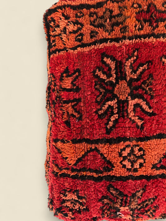 Handwoven Isli Moroccan pouffe in red and orange with Berber tribal patterns