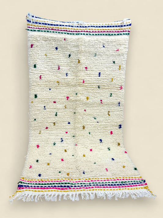 Ivory Berber rug with rainbow stripes and hand-knotted fringe.