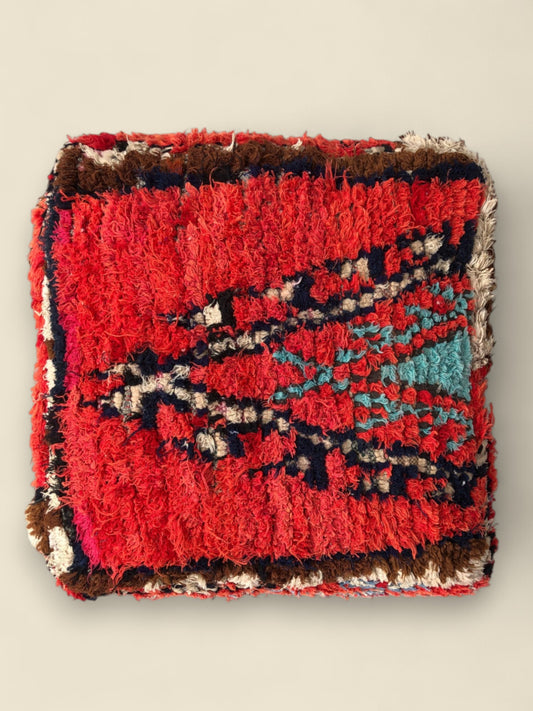 Top view of Tafsut Moroccan pouffe with bold red and geometric Berber patterns