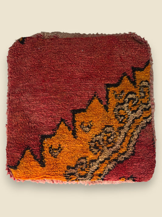 Top view of the Tamghart pouffe showing bold Berber motifs in warm tones