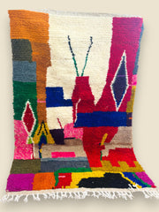 Bright geometric Tawenza Berber rug with red, blue, and cream patterns.