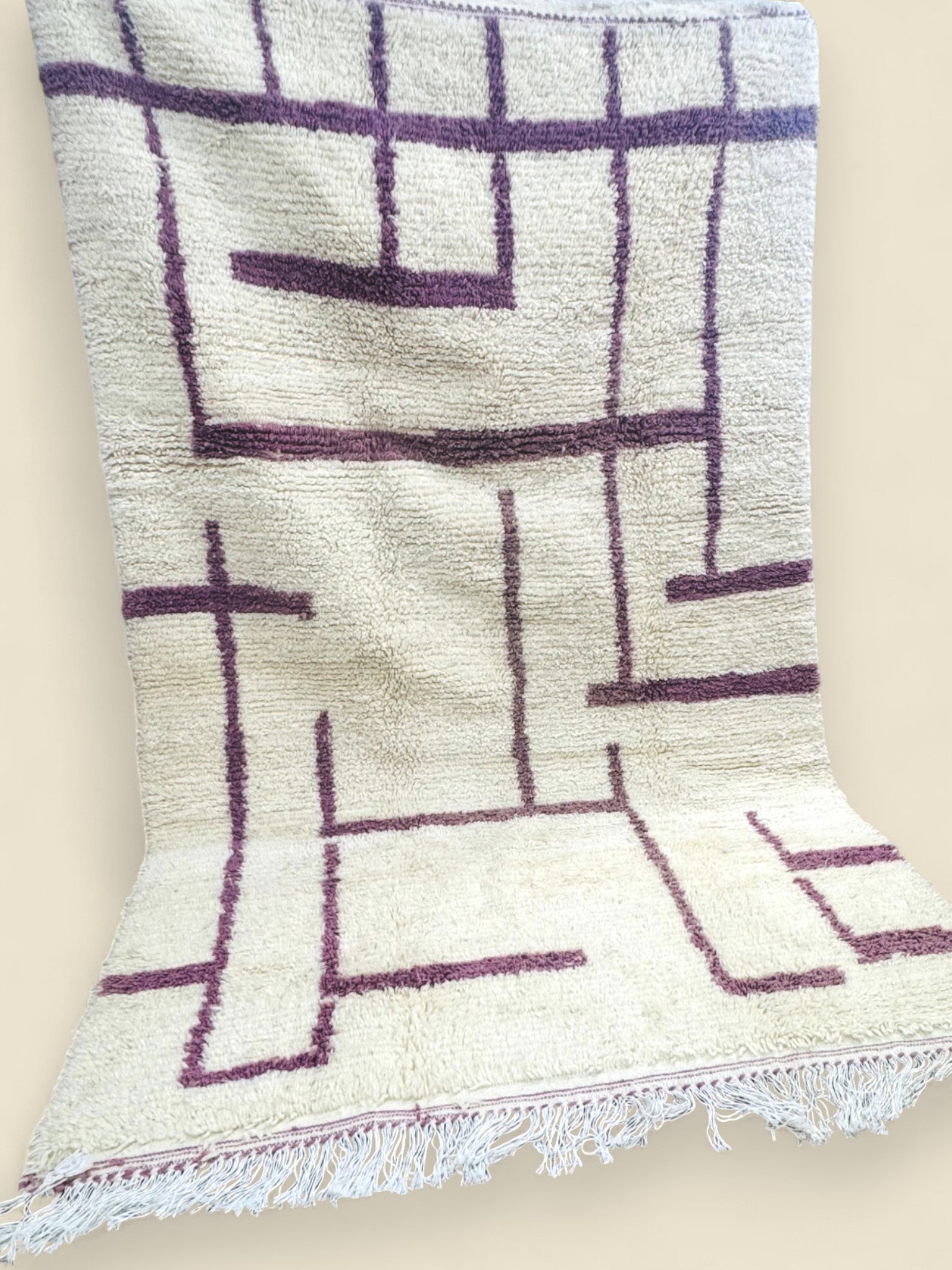 Moroccan wool rug with purple linear pattern and fringed edges