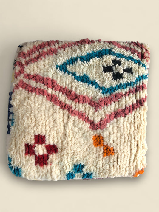 Top-down view showing the cream wool surface with red and teal diamond patterns