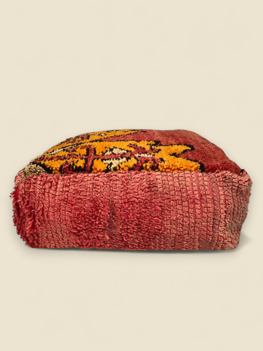 Side view of handwoven Moroccan floor cushion in earthy red tones