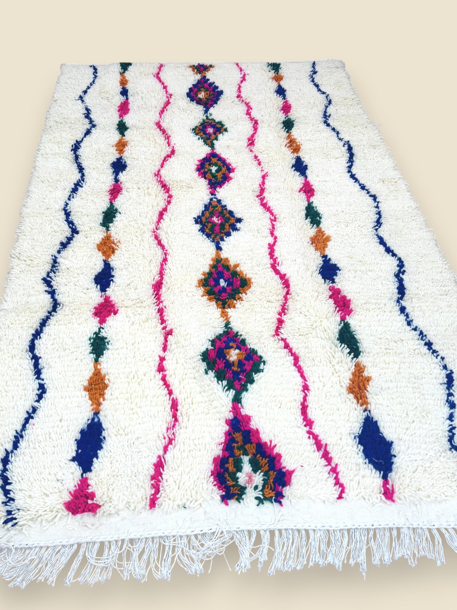 Handmade Tiziriwen Moroccan rug with colorful diamond patterns on ivory wool