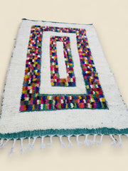 Moroccan Beni Ourain style rug with multicolor center pattern.