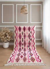 Handmade Moroccan wool rug with pink diamonds displayed upright
