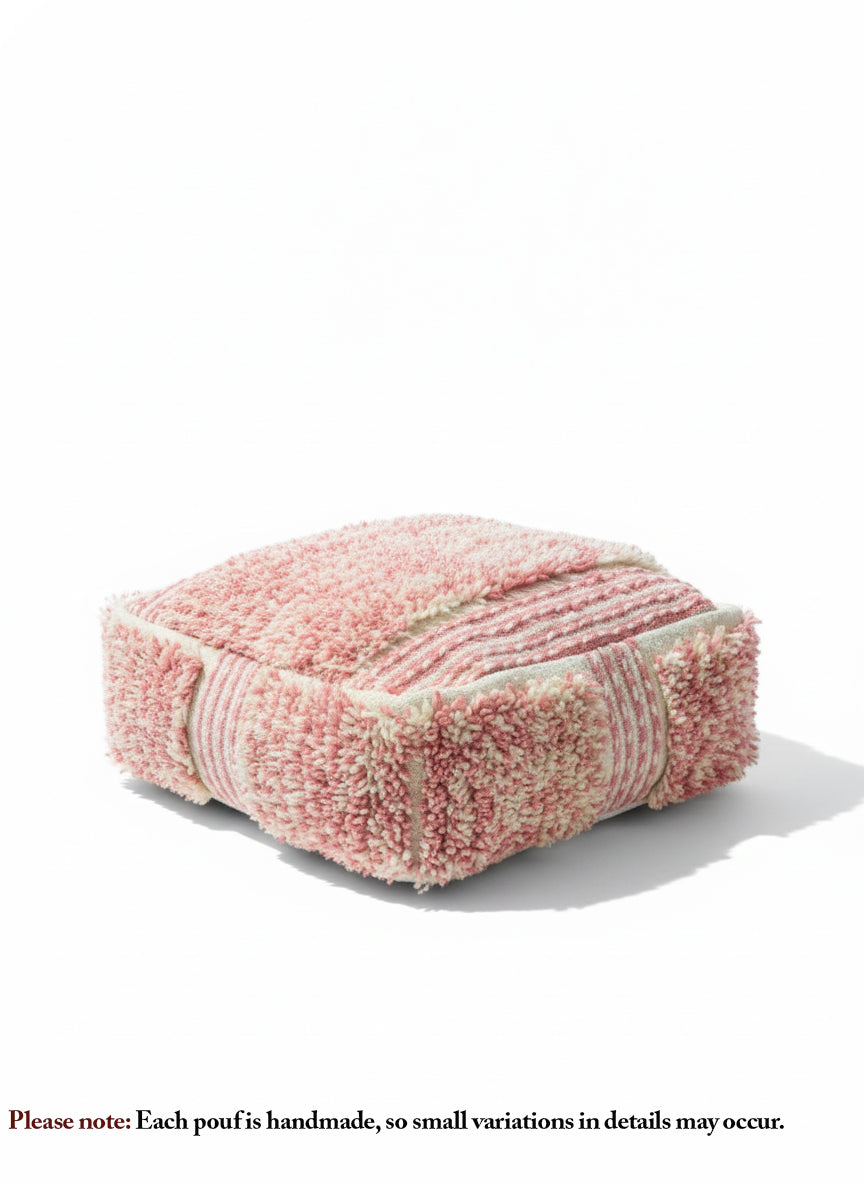 Handmade Moroccan wool pouf in pink and white displayed on a white backdrop.