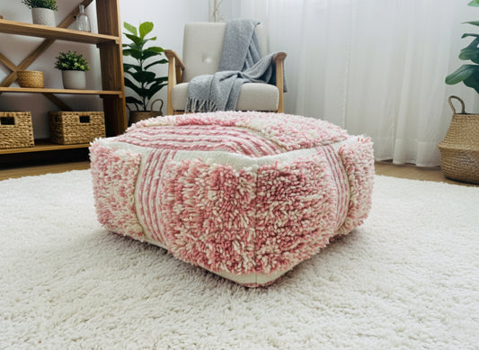 Close-up of a Moroccan pink and white wool pouf with shaggy Berber texture.