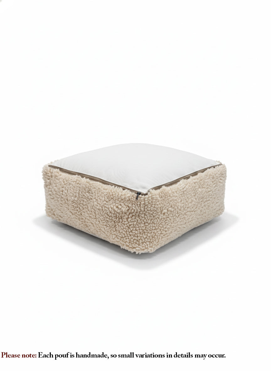 Handmade beige wool pouf with zipper underside, soft sherpa-style texture.