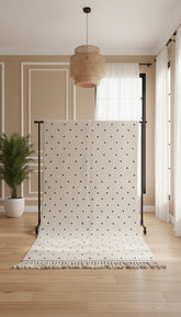 Handwoven Berber Tisran rug with black dot pattern displayed on a rug stand