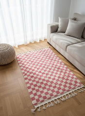 Pink checkered Moroccan wool rug beside sofa