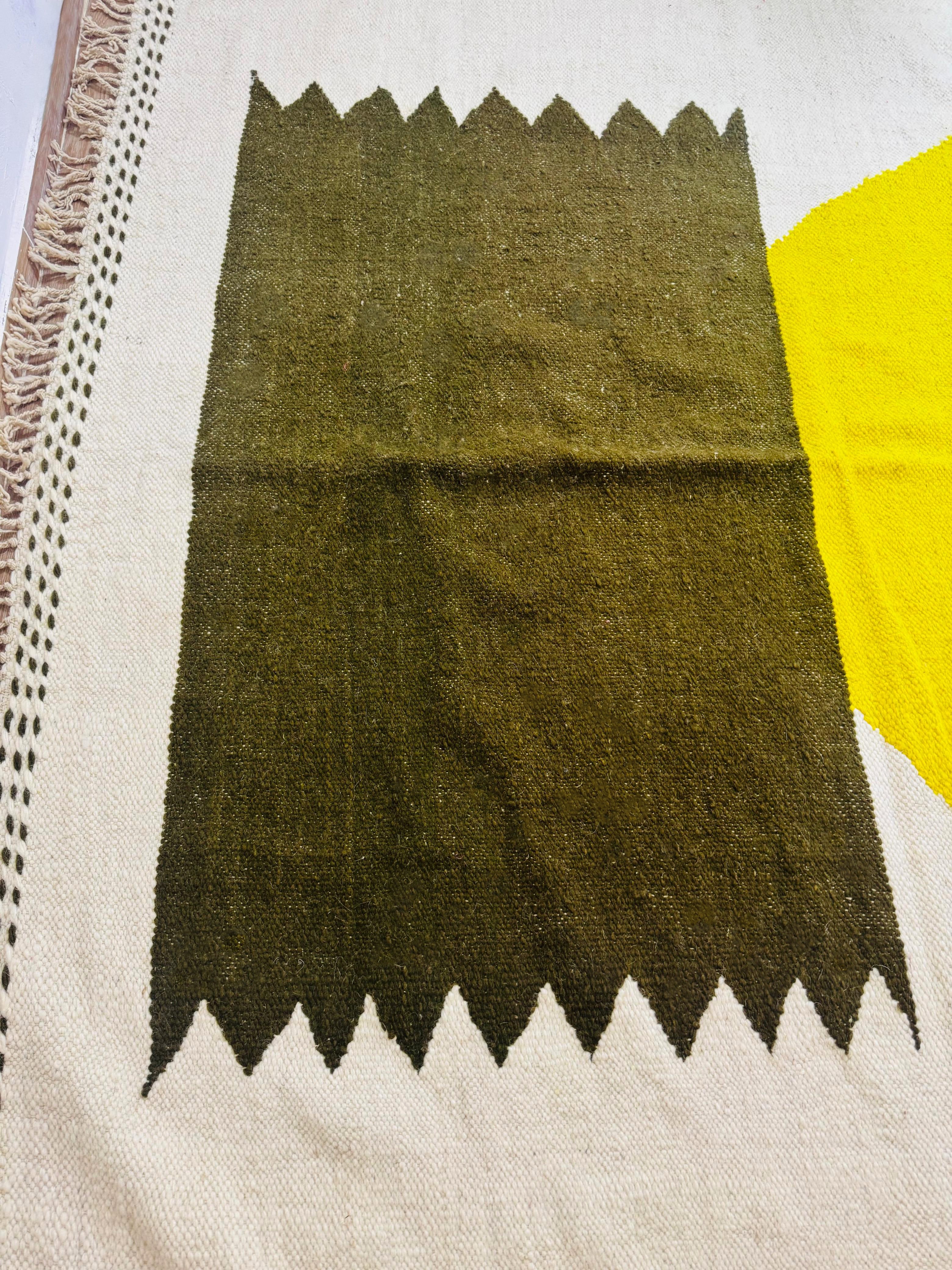 Handwoven Taznurt Berber rug with olive green and mustard yellow geometric pattern on a cream base