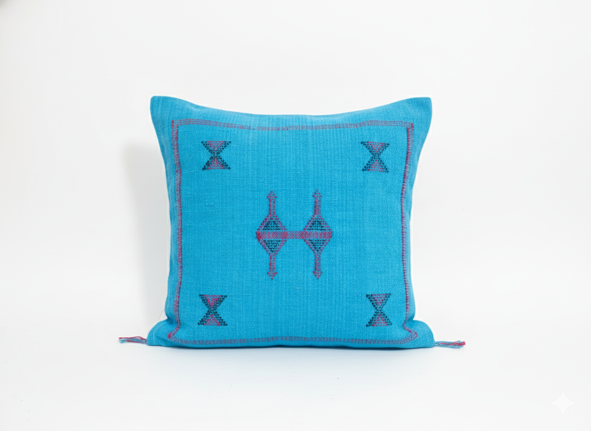 Close-up of turquoise Tasga Berber pillow with traditional embroidery on white background