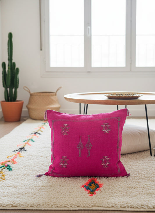 Handmade Moroccan Taklit cactus silk pillow on cream rug and wooden table