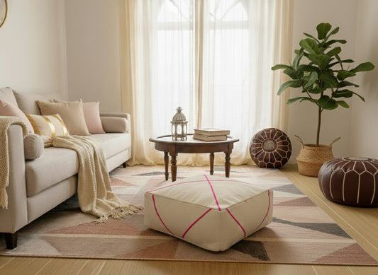 Cream Moroccan wool pouf with pink lines in cozy living room