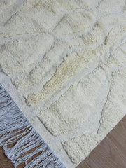 Handmade Tirza beige wool rug with geometric texture and fringed edges