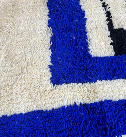 Close-Up of Handmade Moroccan Rug Showing Plush Ivory Wool and Vibrant Blue Pattern