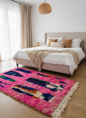 Pink Moroccan wool area rug styled in bedroom