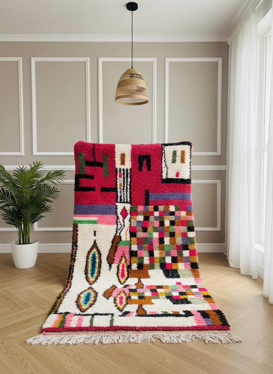 Multicolor Moroccan rug with pink, white, and black geometric motifs