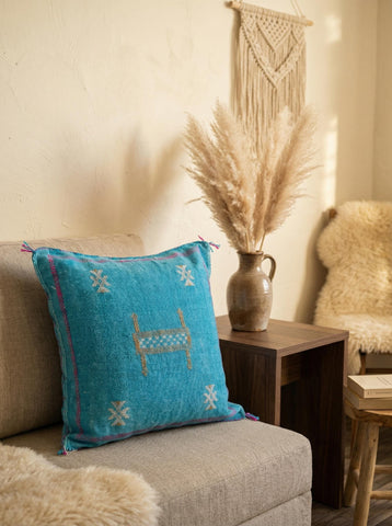 Blue Moroccan pillow on jute rug in natural living room