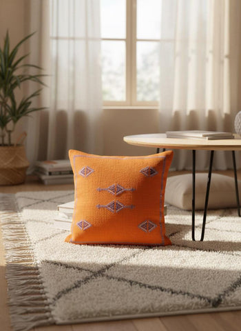 Handwoven orange Berber pillow on living room rug