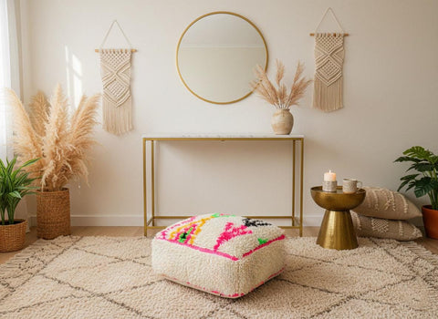 Square Moroccan wool pouf beside wooden armchair