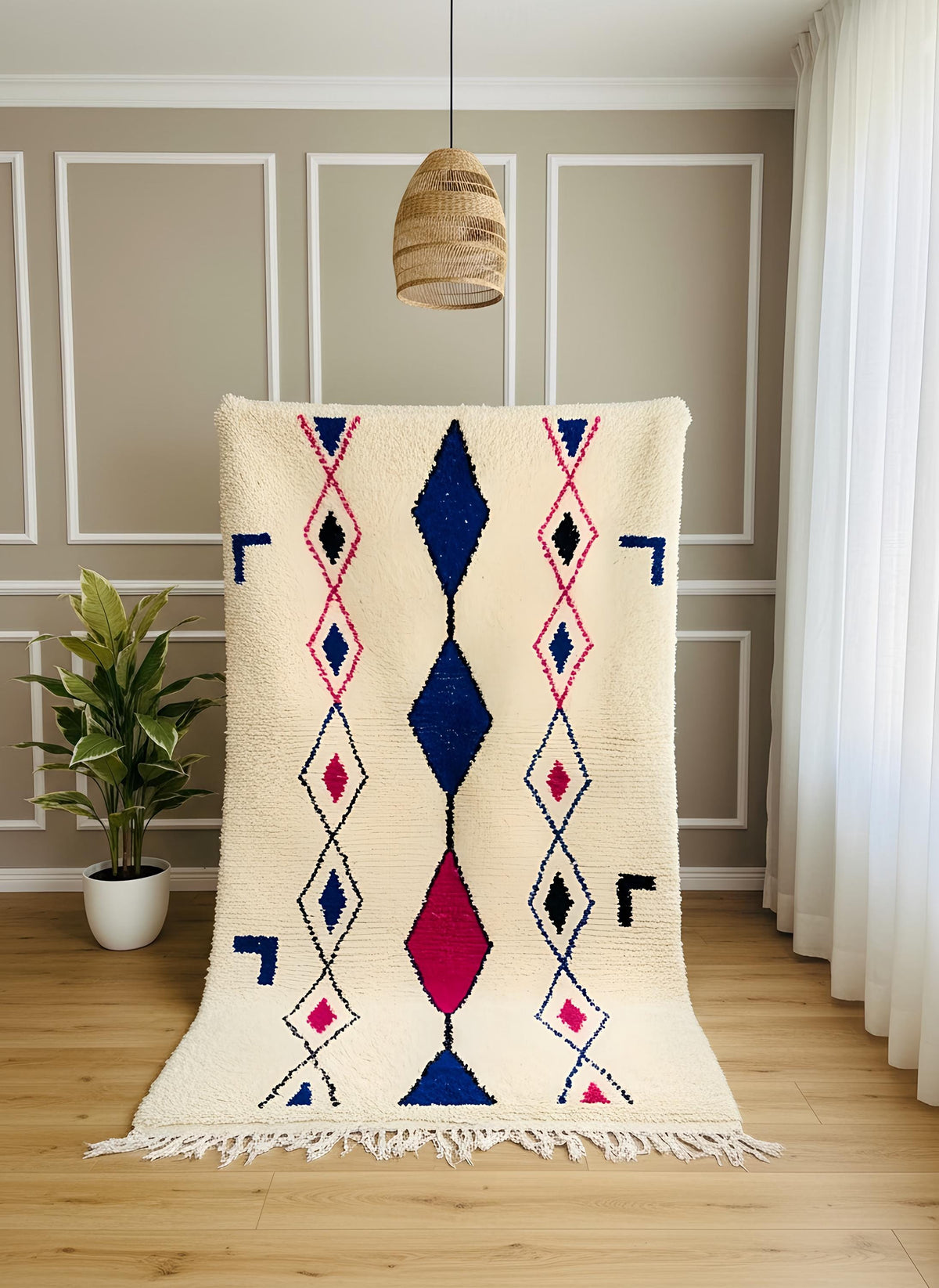 Handmade Moroccan Berber rug displayed vertically with blue and pink diamond pattern on a cream wool base.
