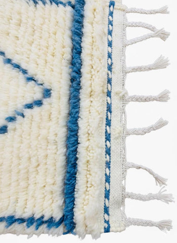Detailed texture of ivory wool pile with blue pattern