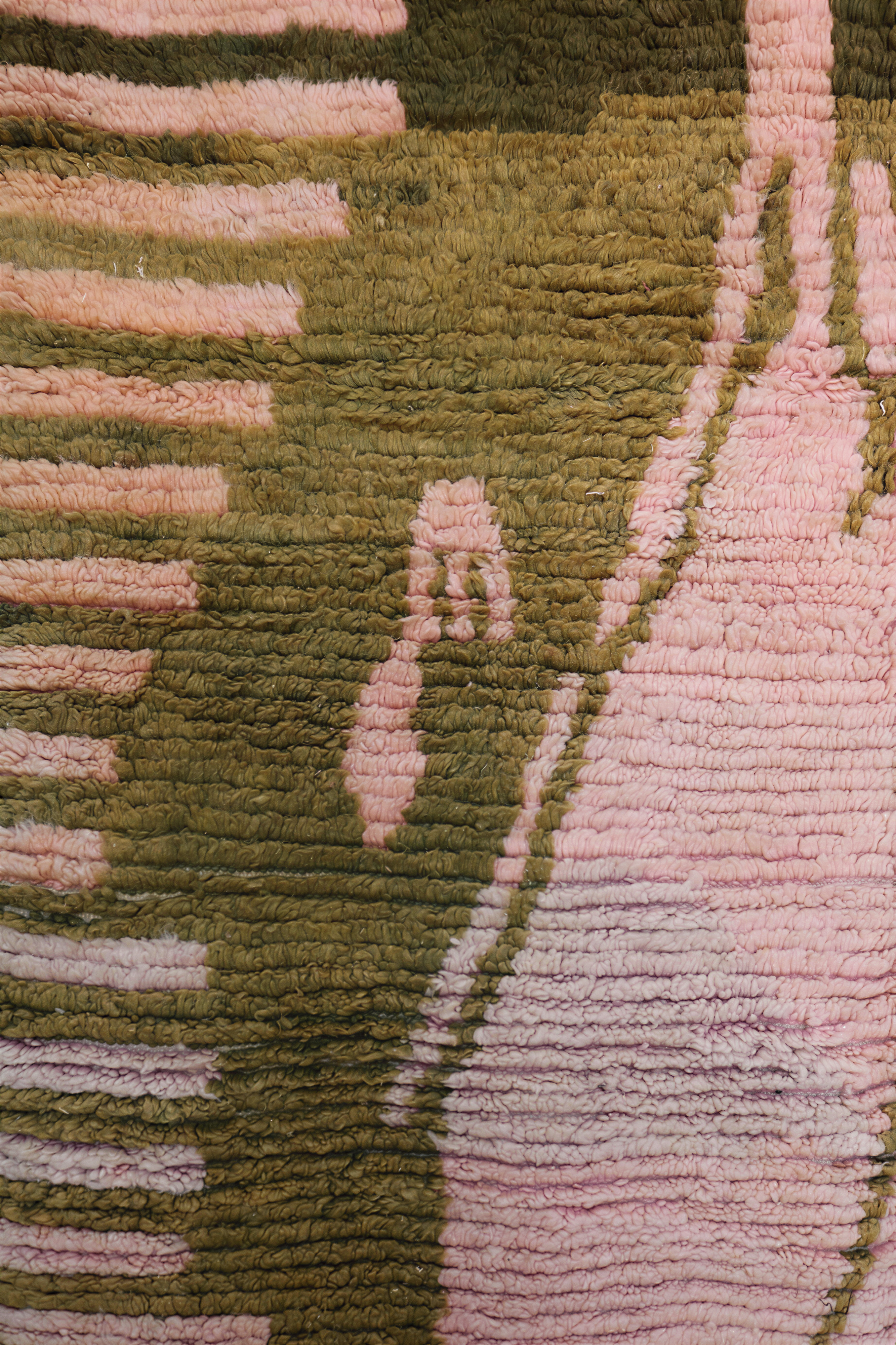 Detail of Moroccan rug center design featuring pink abstract form outlined with olive green and blue lines