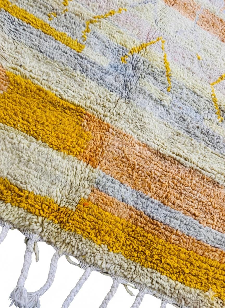 Detailed texture of Moroccan yellow and peach wool rug with thick high pile.