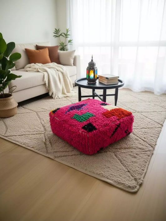 Bright fuchsia Moroccan pouf in a modern living room.