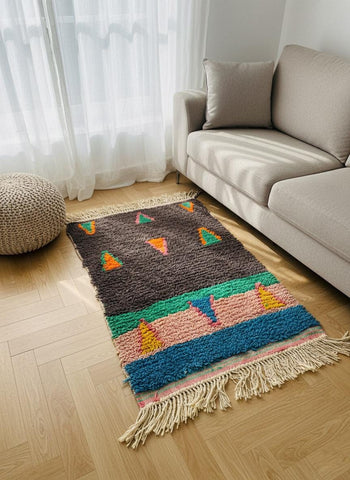 Moroccan wool rug styled beside sofa and pouf