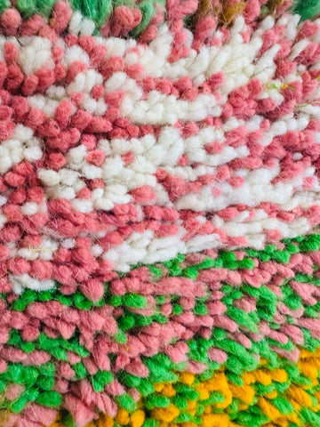 Pink, green and yellow striped Berber rug detail.