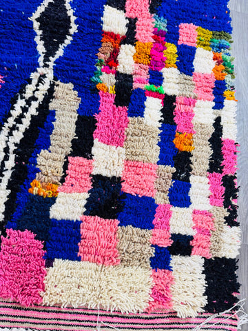 Textured pink and blue rug detail close-up