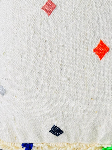 Detailed view of Berber wool pouf fabric with colorful geometric dots