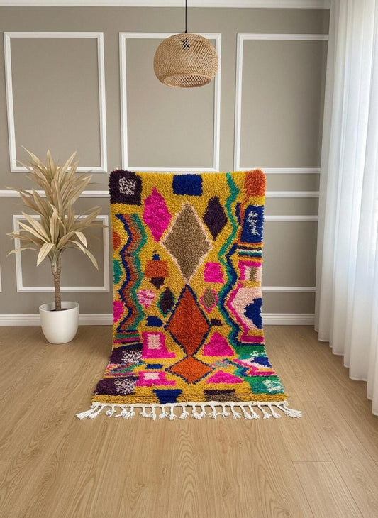 Handmade yellow wool rug with vibrant geometric design displayed upright