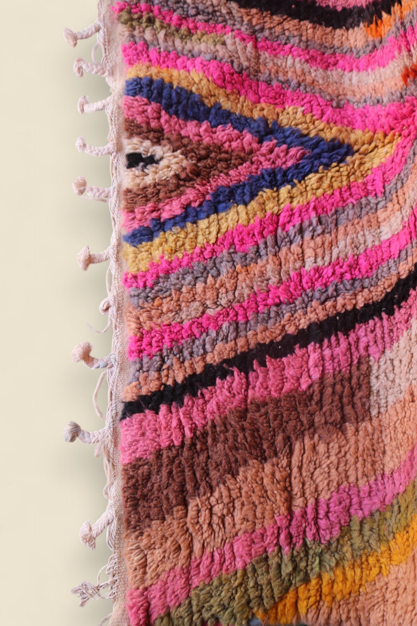 Corner detail of vintage Anir rug with multicolored stripes and knotted tassels