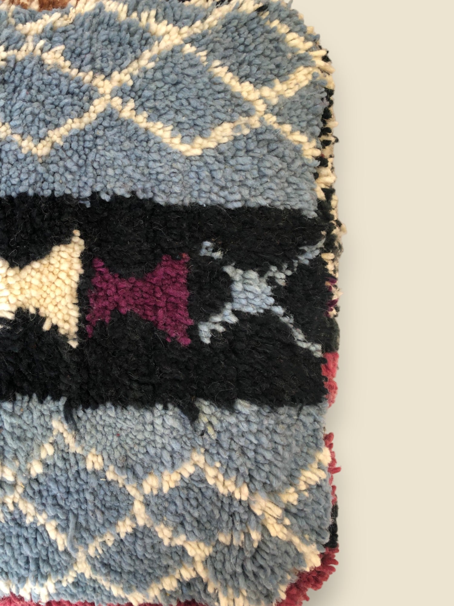 Close-up of textured wool surface with cream-on-blue diamond designs