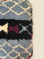 Close-up of textured wool surface with cream-on-blue diamond designs