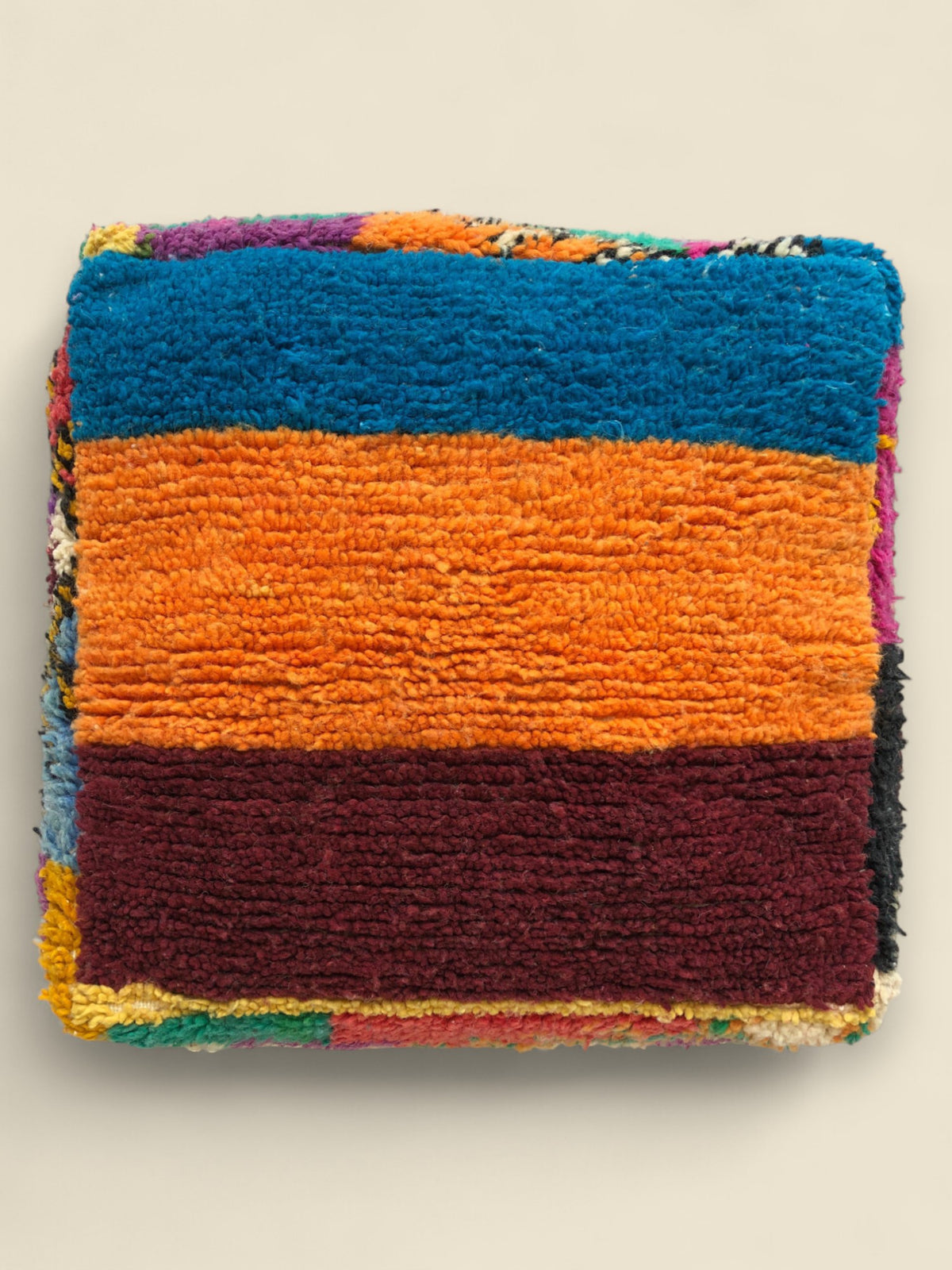 Angled view of colorful Asmoun Moroccan floor cushion