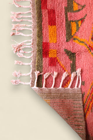 Corner of the Limra rug flipped to show woven underside and vibrant wool pile