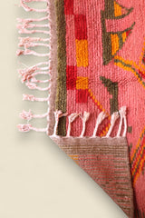 Corner of the Limra rug flipped to show woven underside and vibrant wool pile