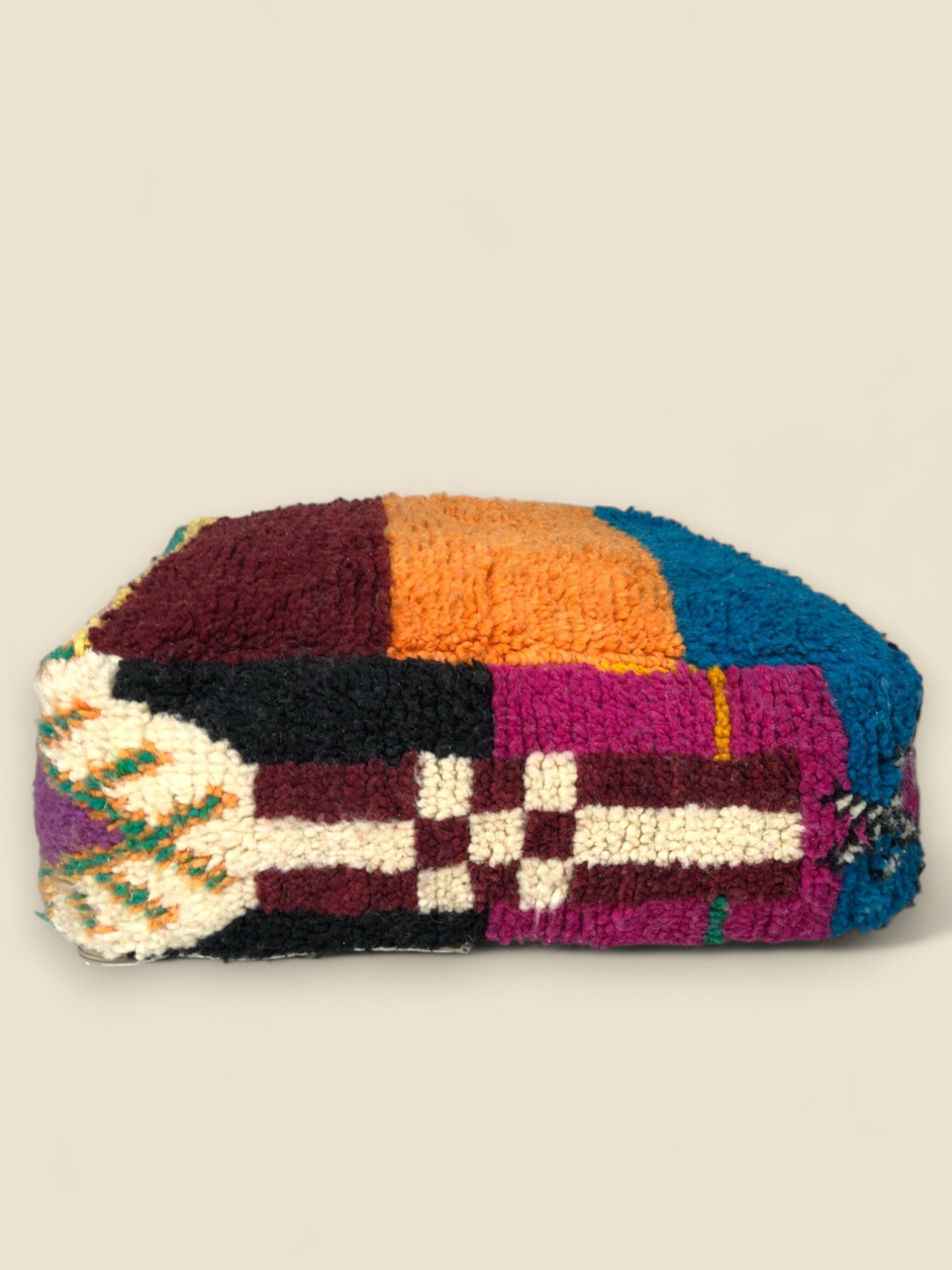 Side angle of Asmoun pouffe with traditional Berber patterns in wool

