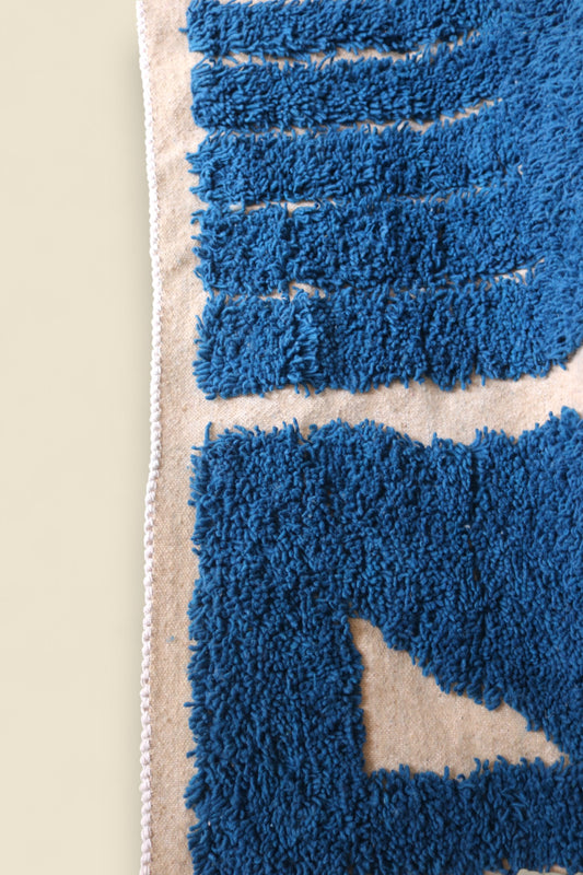 Corner of Ziriya rug showing white braided edge and plush wool